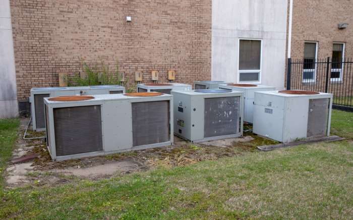 many old air conditioner units outside building picture id1139131562 1 1