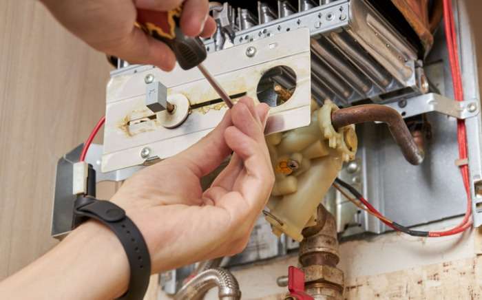 service technician repairing gas water heater indoors water heater picture id1266343018 1