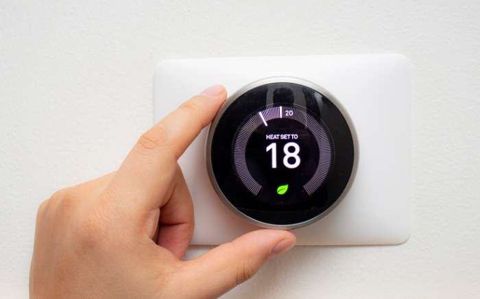 smart thermostat with a person saving energy with a soft shadow picture id1194920571 1