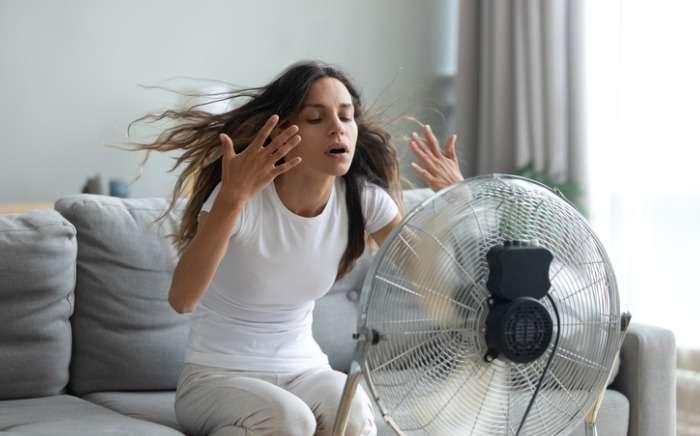 woman turned on fan waving her hands to cool herself picture id1192627562 2 1