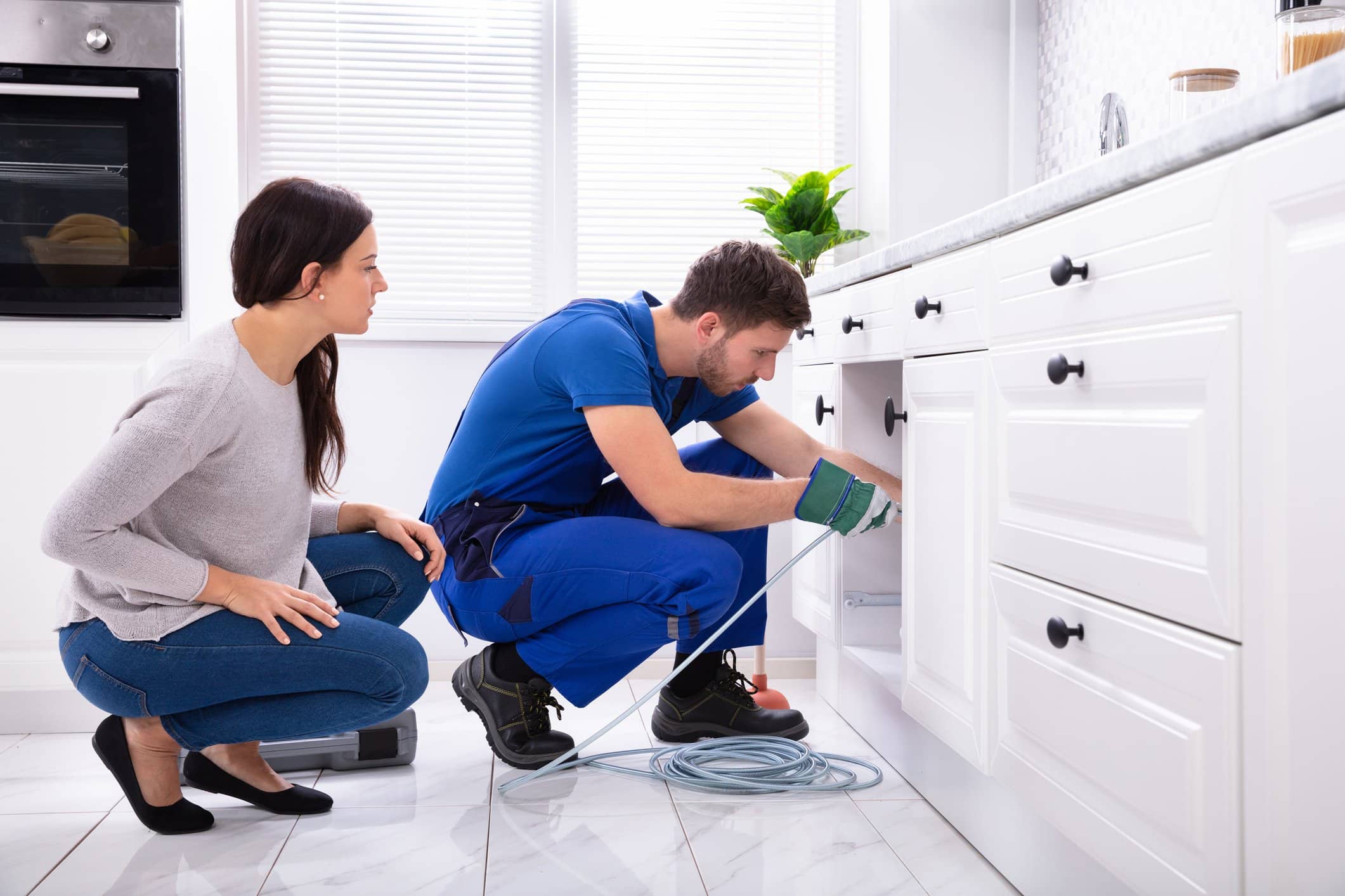 plumber looking at woman's plumbing problem