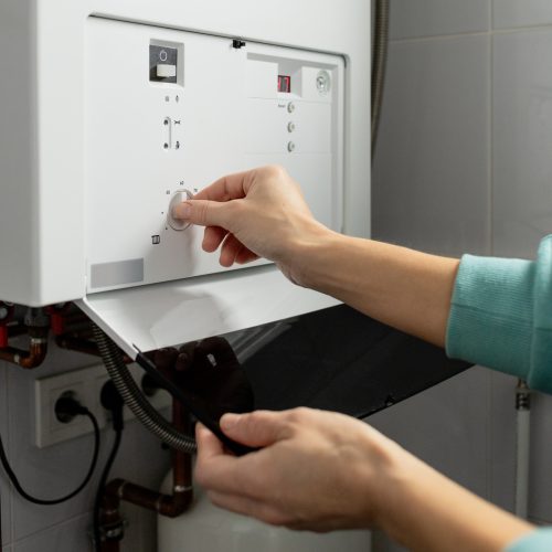 A woman reduces the power of the gas boiler in her home due to an energy crisis
